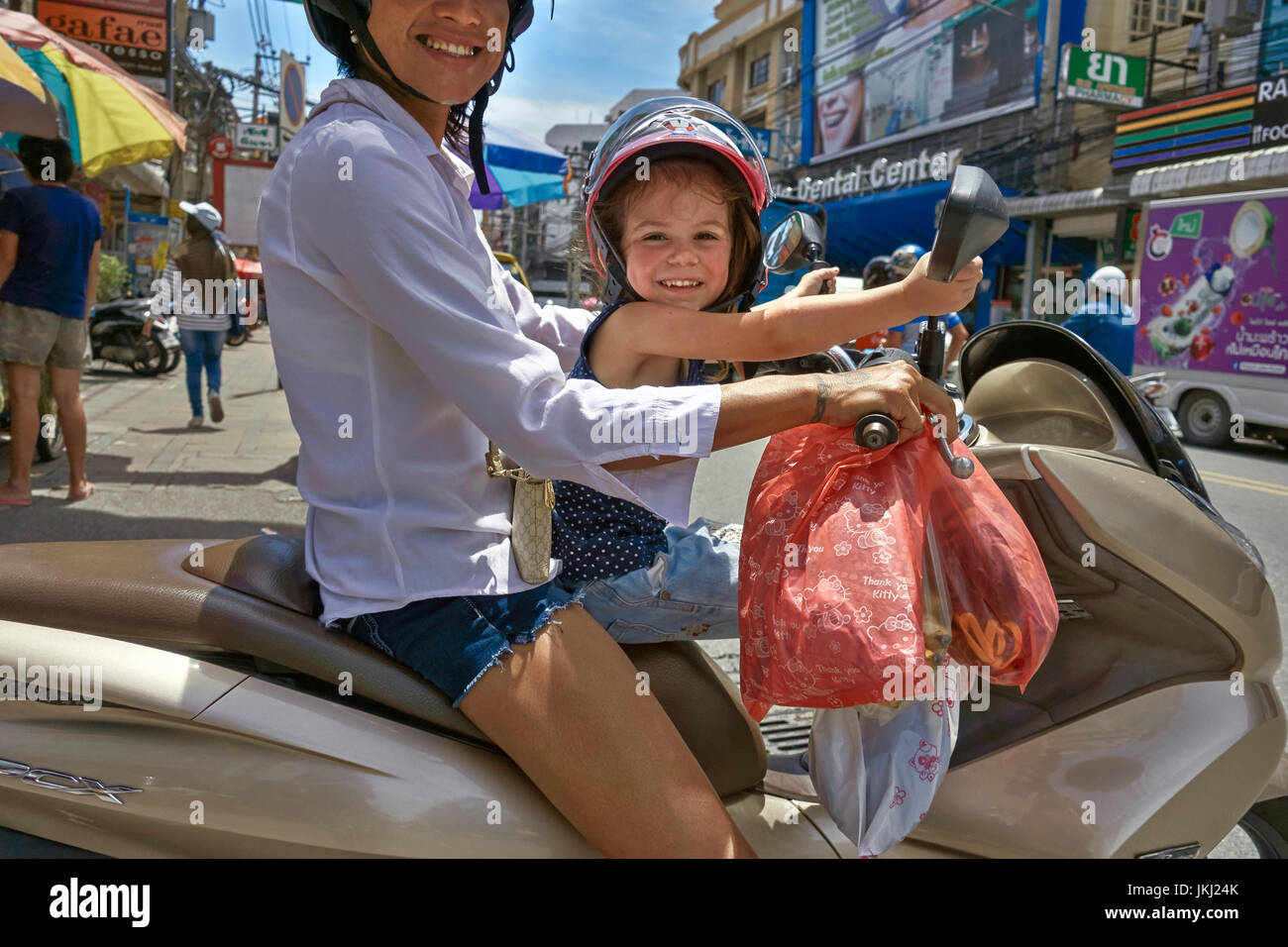 Mother with child passenger riding a motorcycle in Thailand Southeast