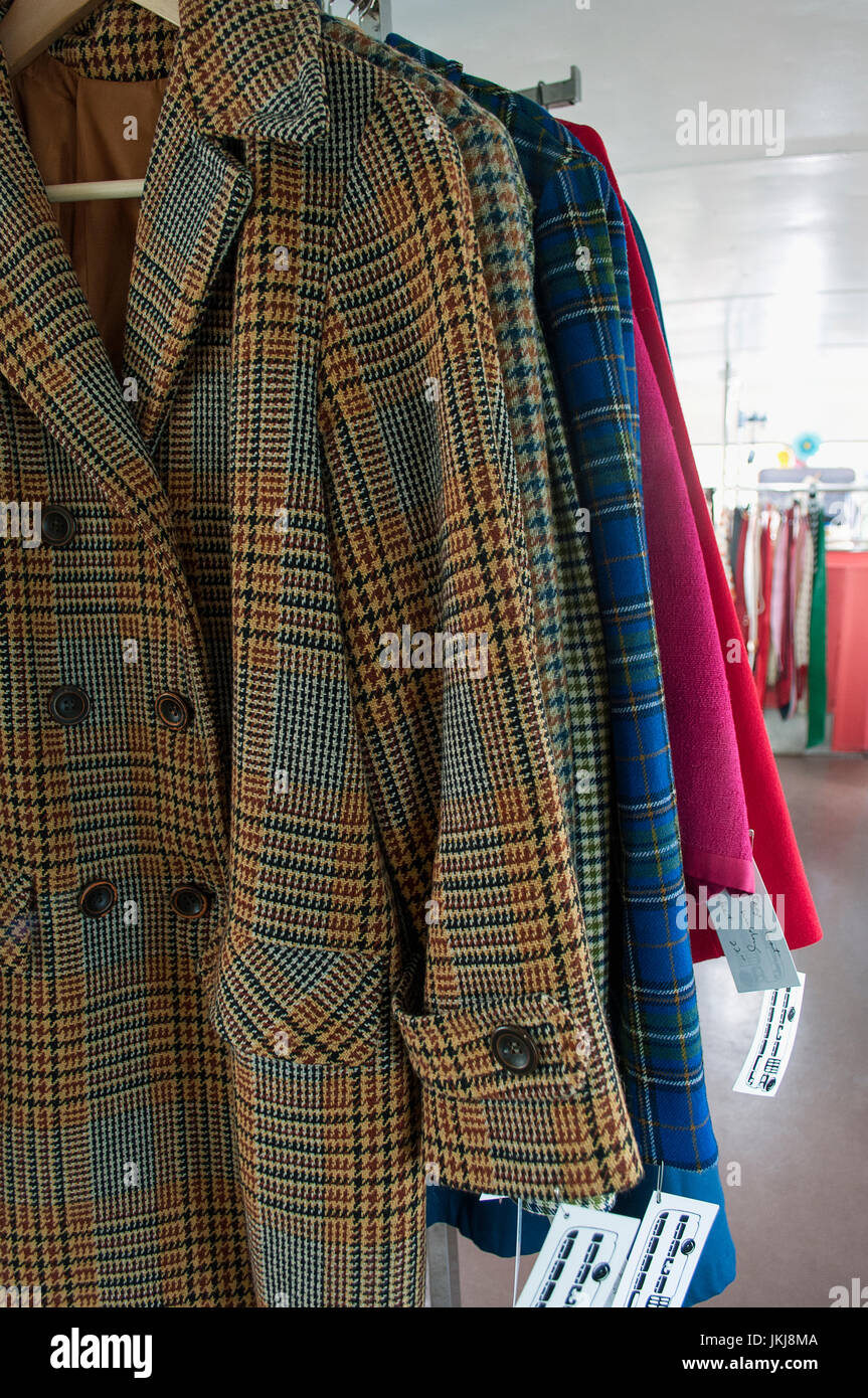 Coats and jackets for sale at a vintage clothing store. Stock Photo