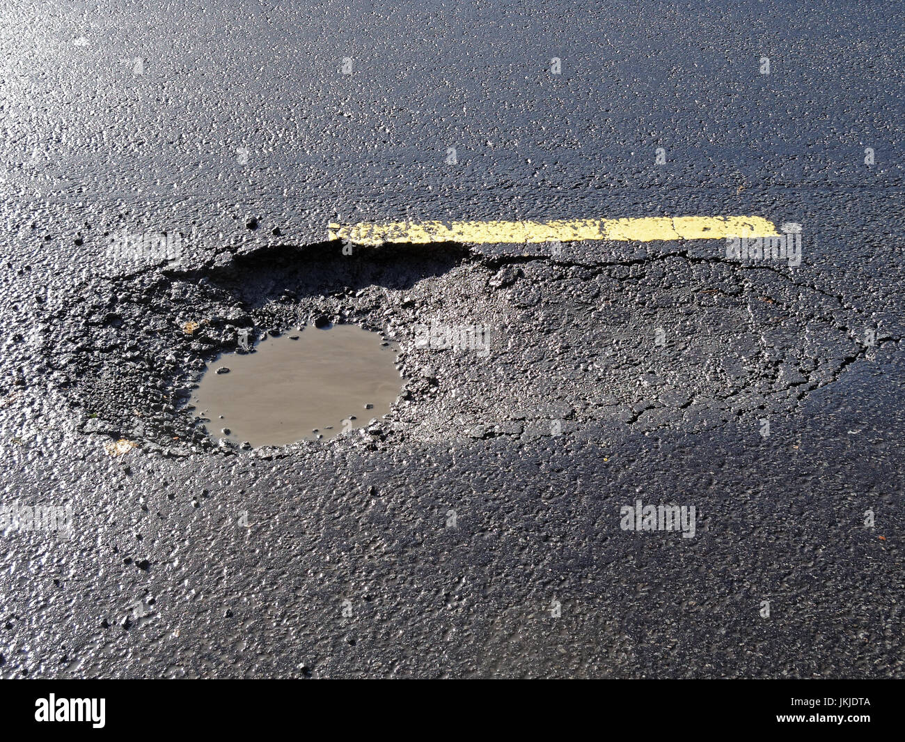 large pothole on road filled with water glasgow scotland uk Stock Photo
