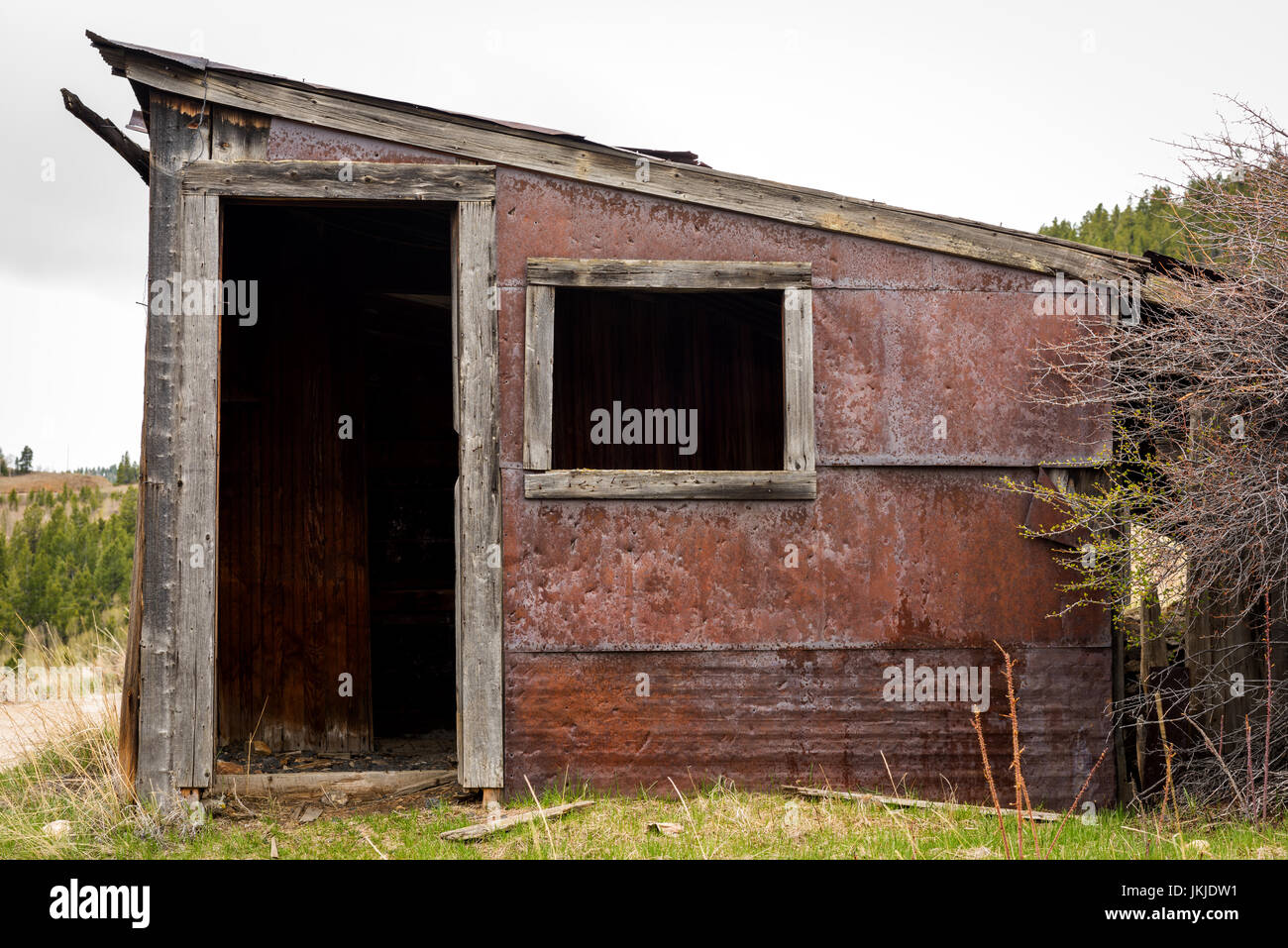 Old hammered tin siding with rust covering a small building Stock Photo ...