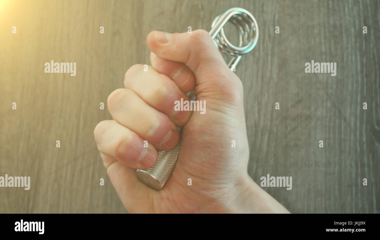 hand expander in the hand of a young athlete. sun effect Stock Photo ...