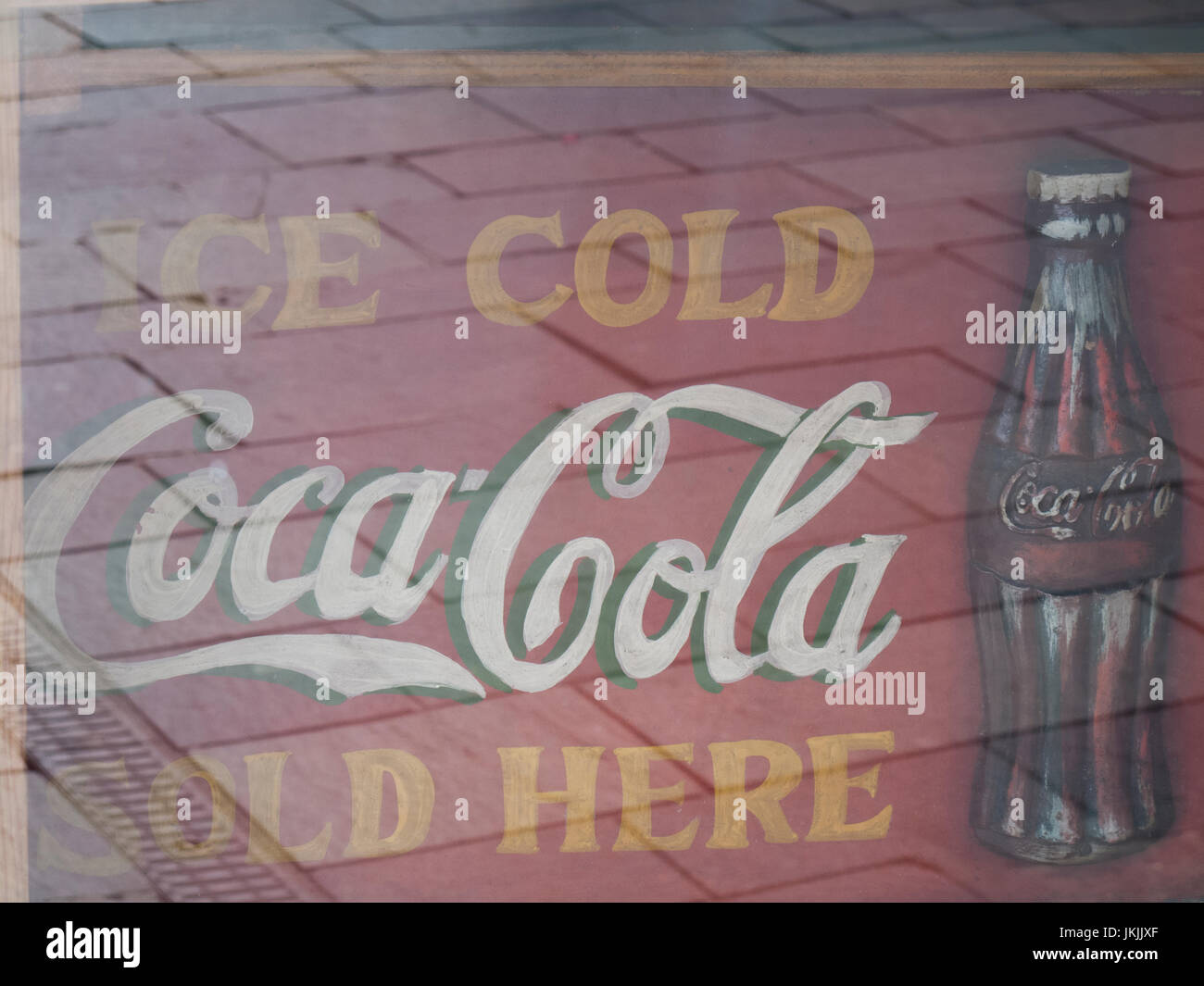  Faded retro ice cold Coca Cola sold here sign in cafe window, carbonated soft drink invented
