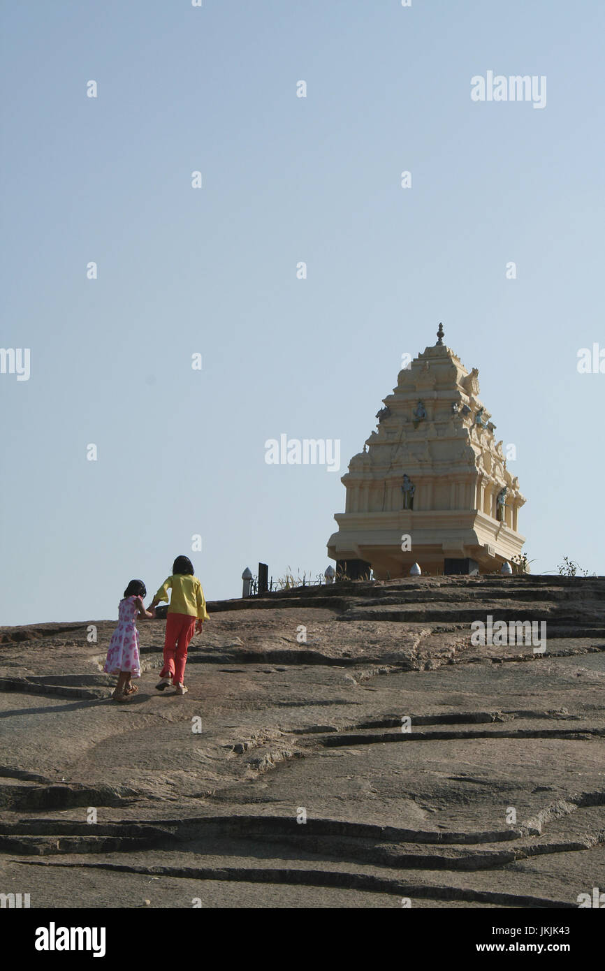 Two sisters climbing rock bed to reach Kempegowda Tower at Lalbagh, Bangalore, India, Asia Stock Photo