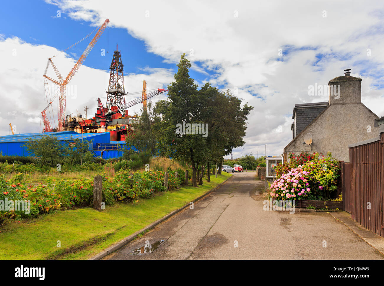 Invergordon typical detached house, nice view, industrial area with oil rig fabrication in the background. Stock Photo