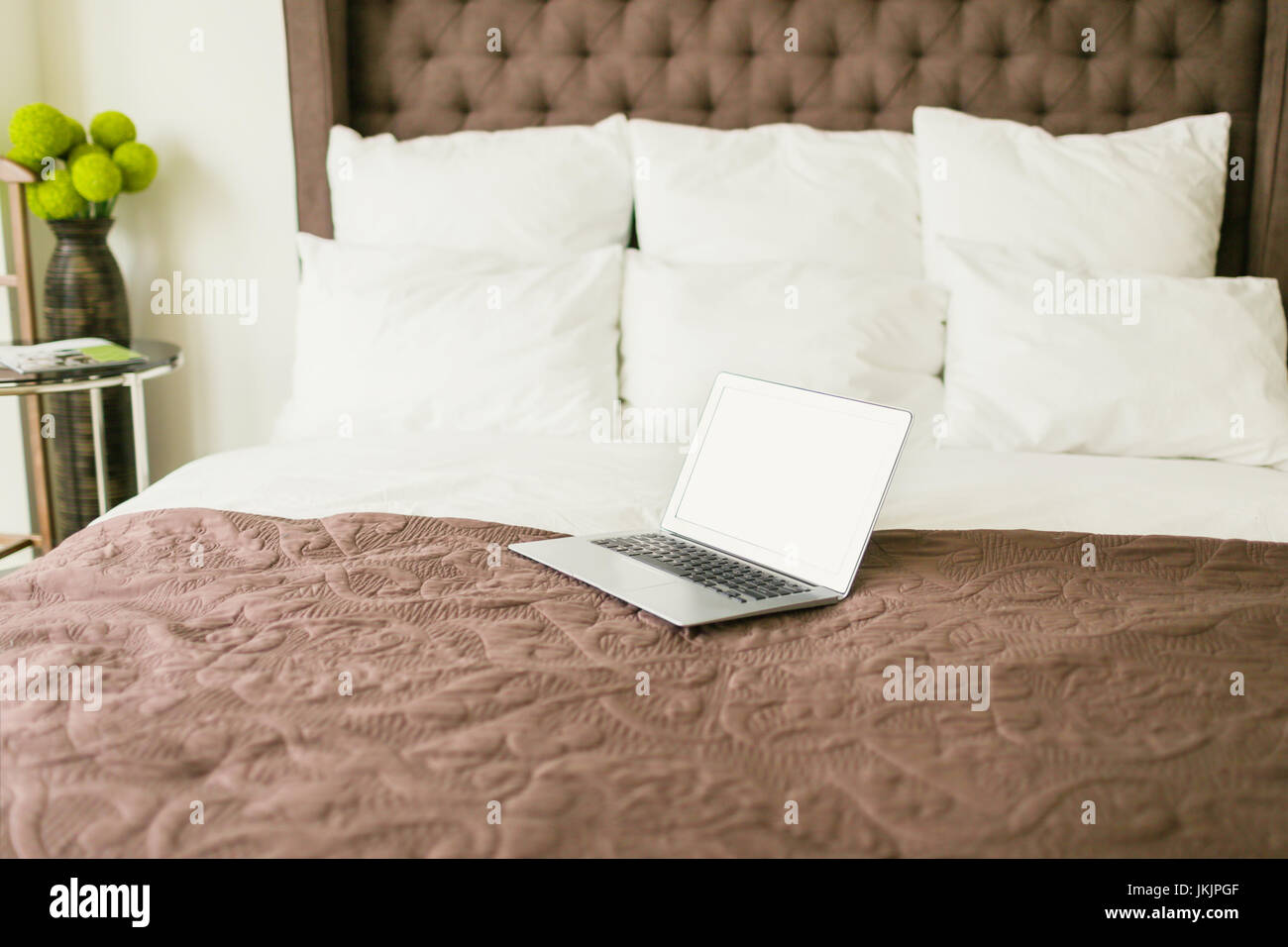 Laptop on bed with pillows Stock Photo Alamy