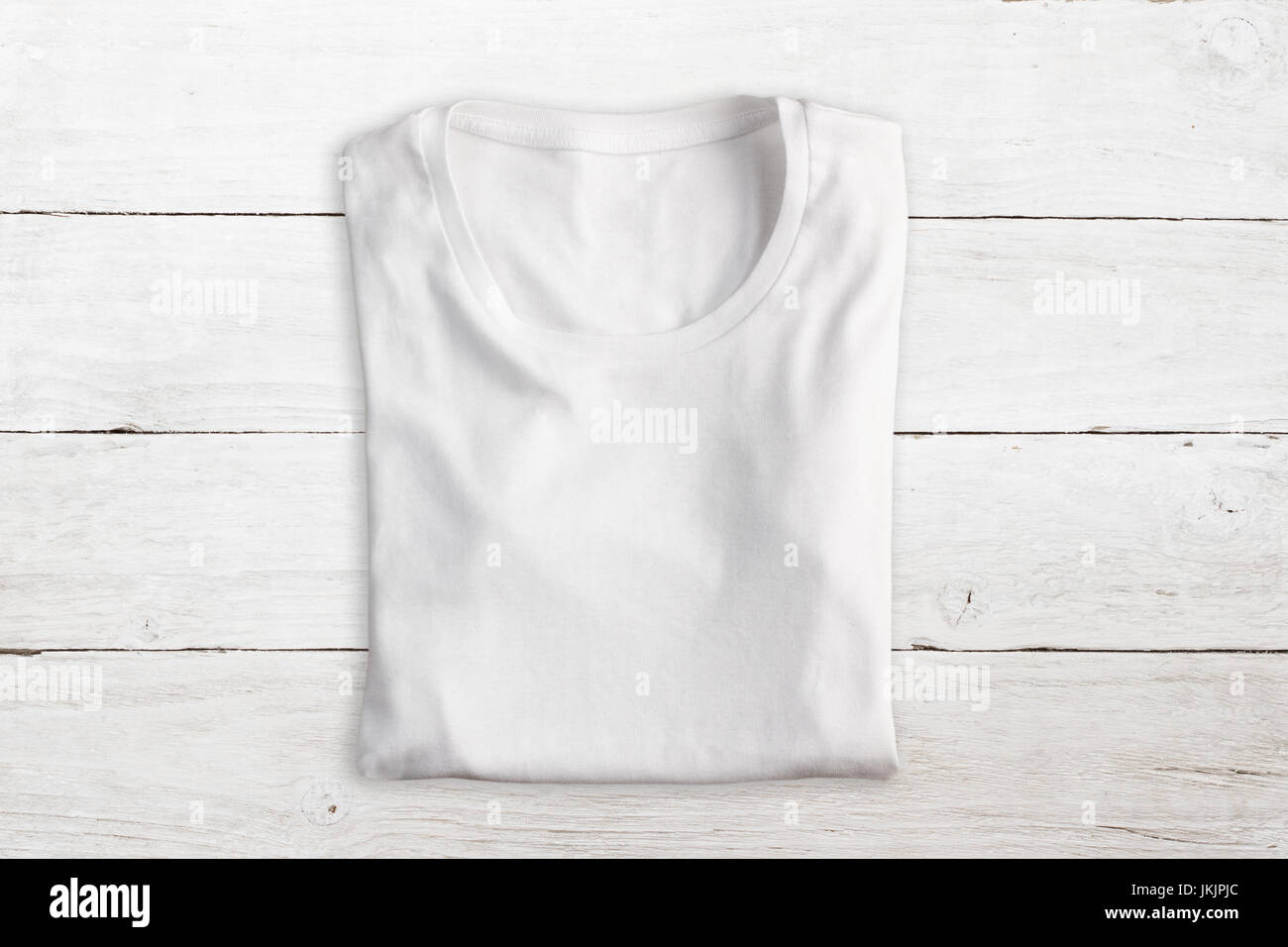 White folded t-shirt on wooden texture Stock Photo