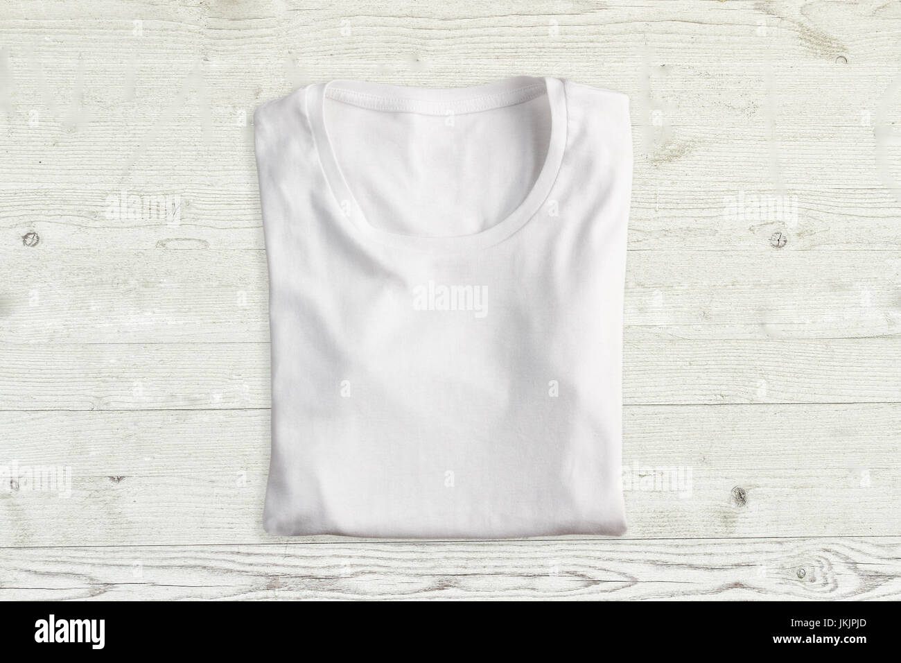 White folded t-shirt on wooden texture Stock Photo