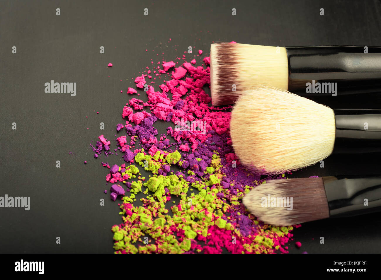 Make-up brushes with color eyeshadow on black Stock Photo
