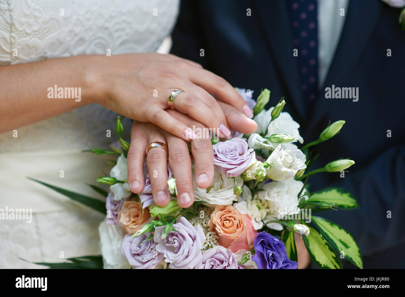 Hands of the bride and groom on a bridal bouquet Stock Photo - Alamy