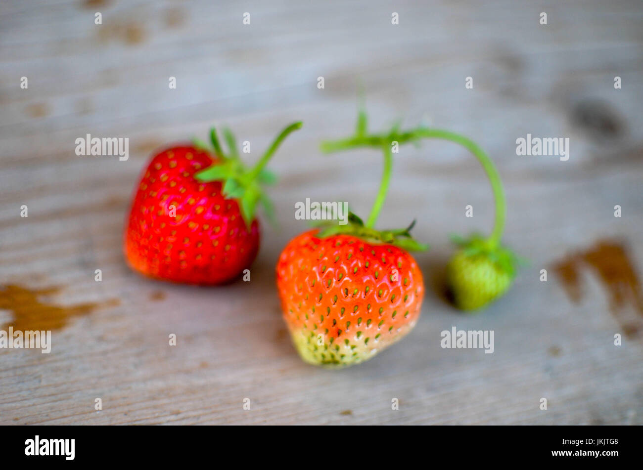 Strawberries red and green on the wood backgrounds Stock Photo - Alamy