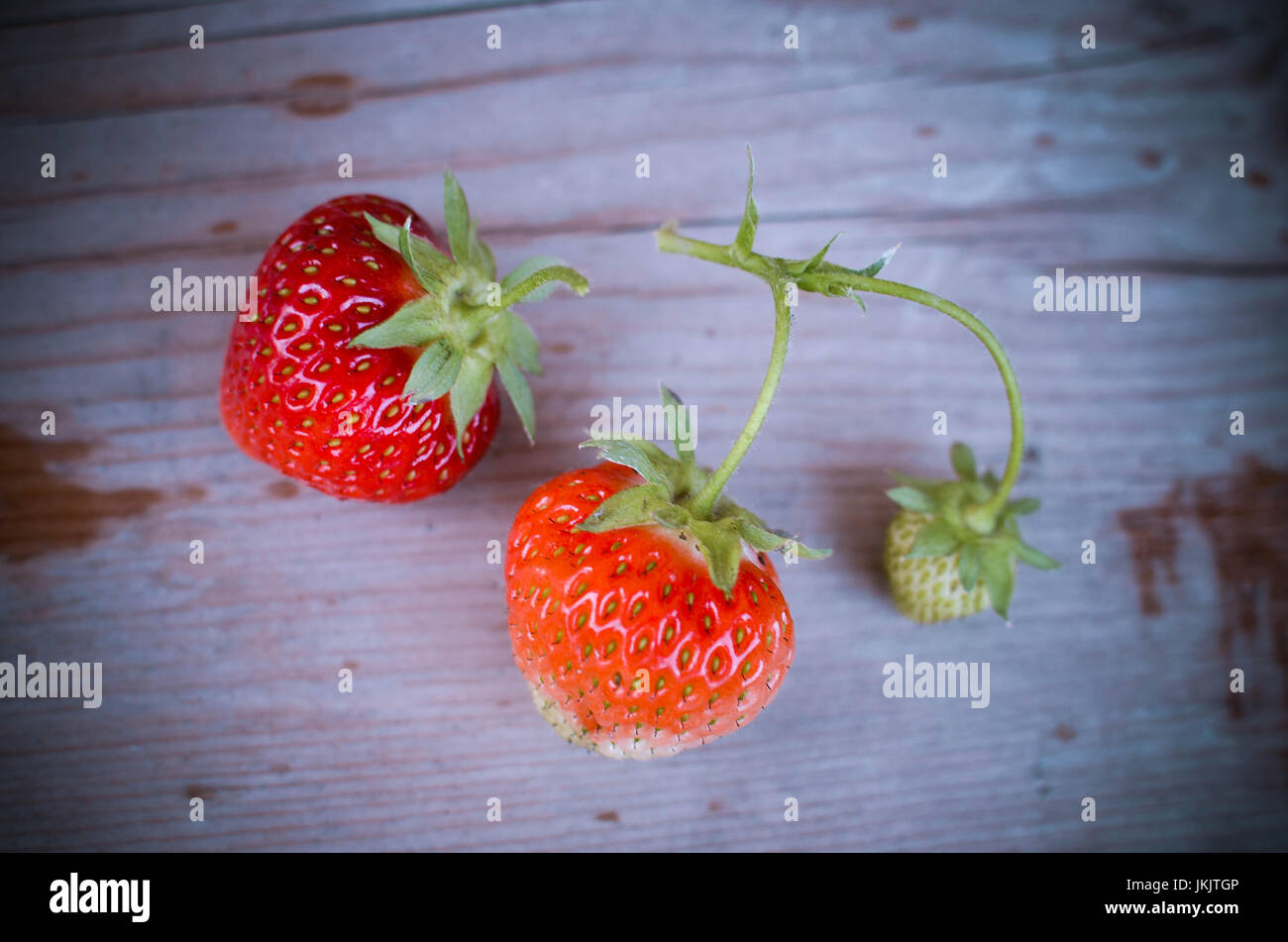 Strawberries red and green on the wood backgrounds Stock Photo - Alamy