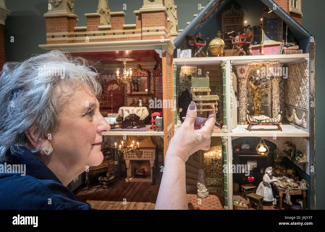 Newby Hall employee Trish Sidebottom holds a chair from a dolls house created by miniaturist Jane Fiddick, at Newby Hall, Yorkshire. Stock Photo