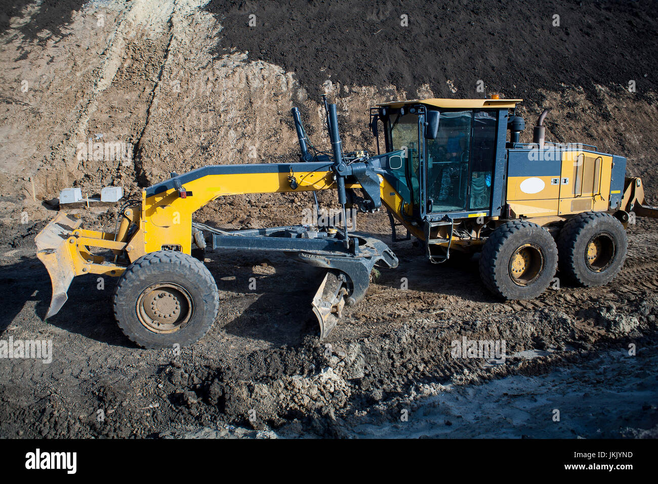 The construction machine Motor Grader level the ground with the