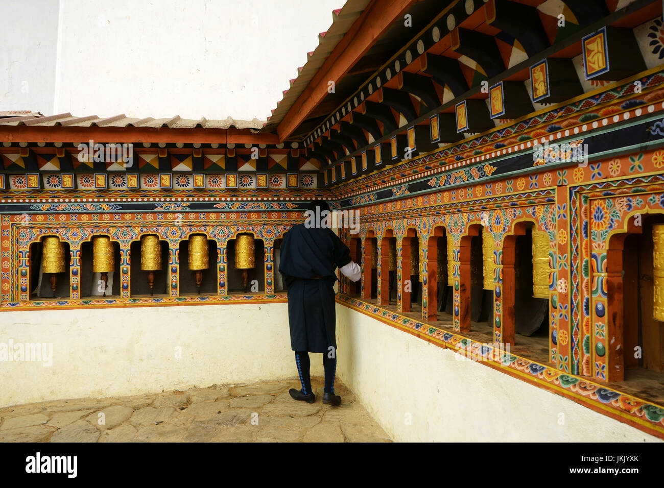 Bhutanese man spinning pryer wheels at Gangtey Monastery above Phobjikha valley, Bhutan Stock Photo