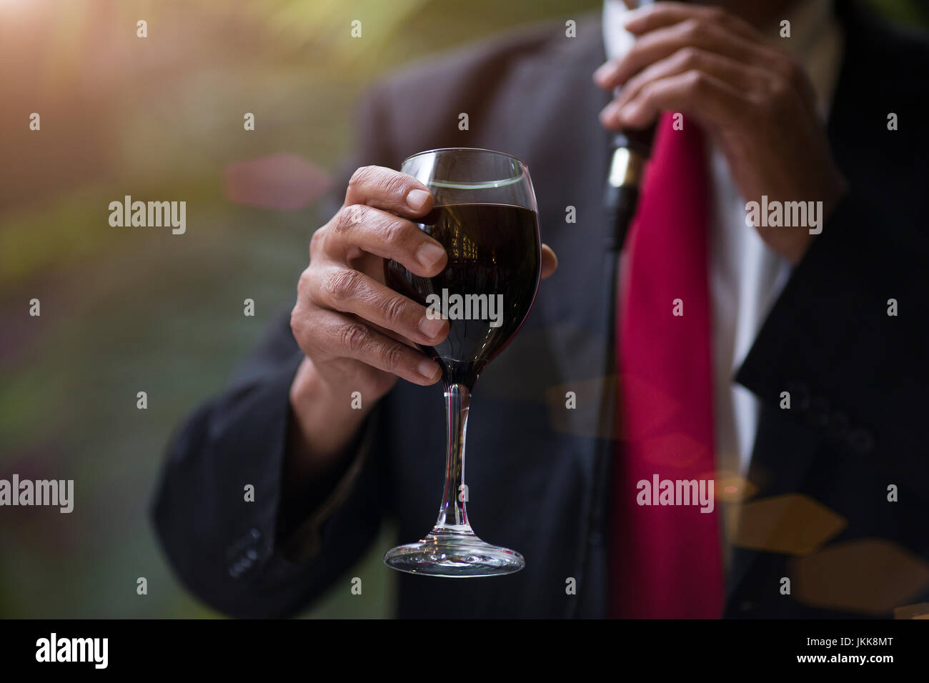 Close-up shooting of man's hand holding a glass of wine Stock Photo