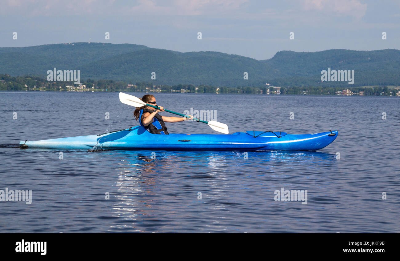 woman kayaking on a calm lake alone Stock Photo
