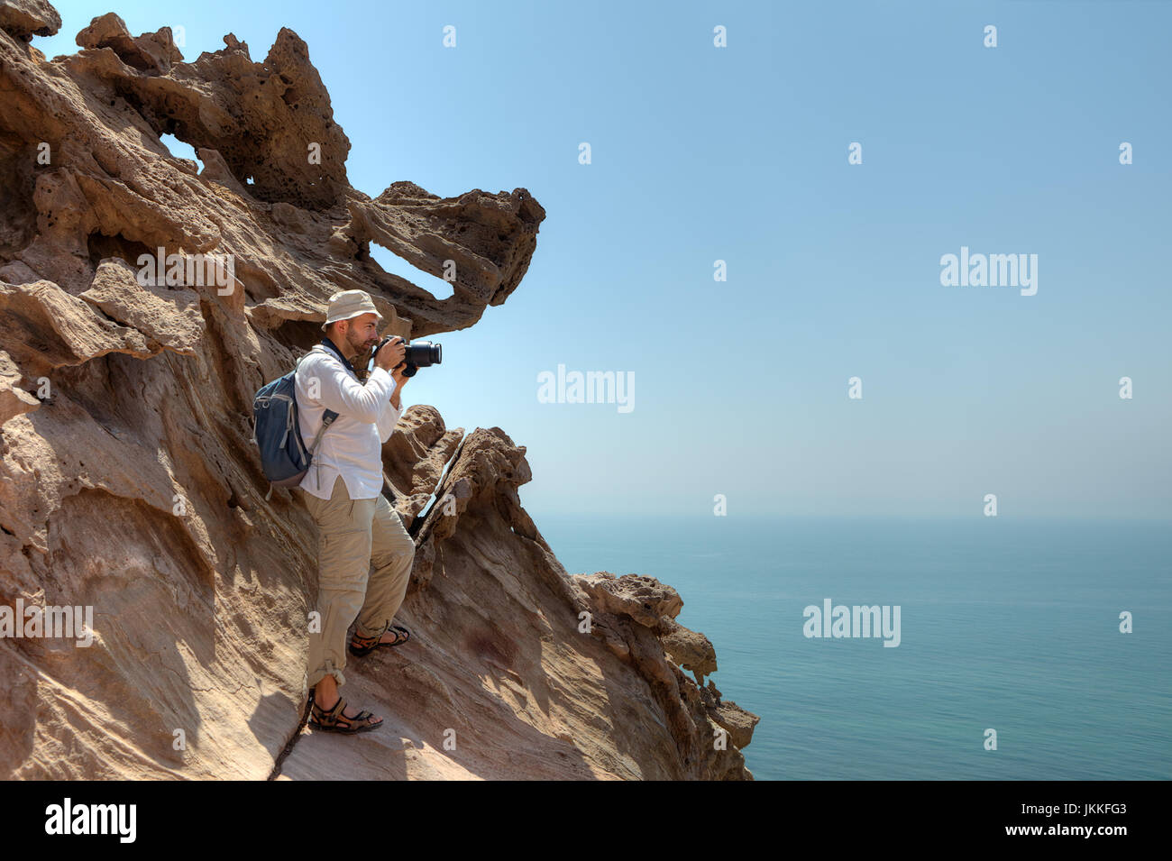 Photographer traveler stands on rock in Hormoz Island, southern Iran. Stock Photo