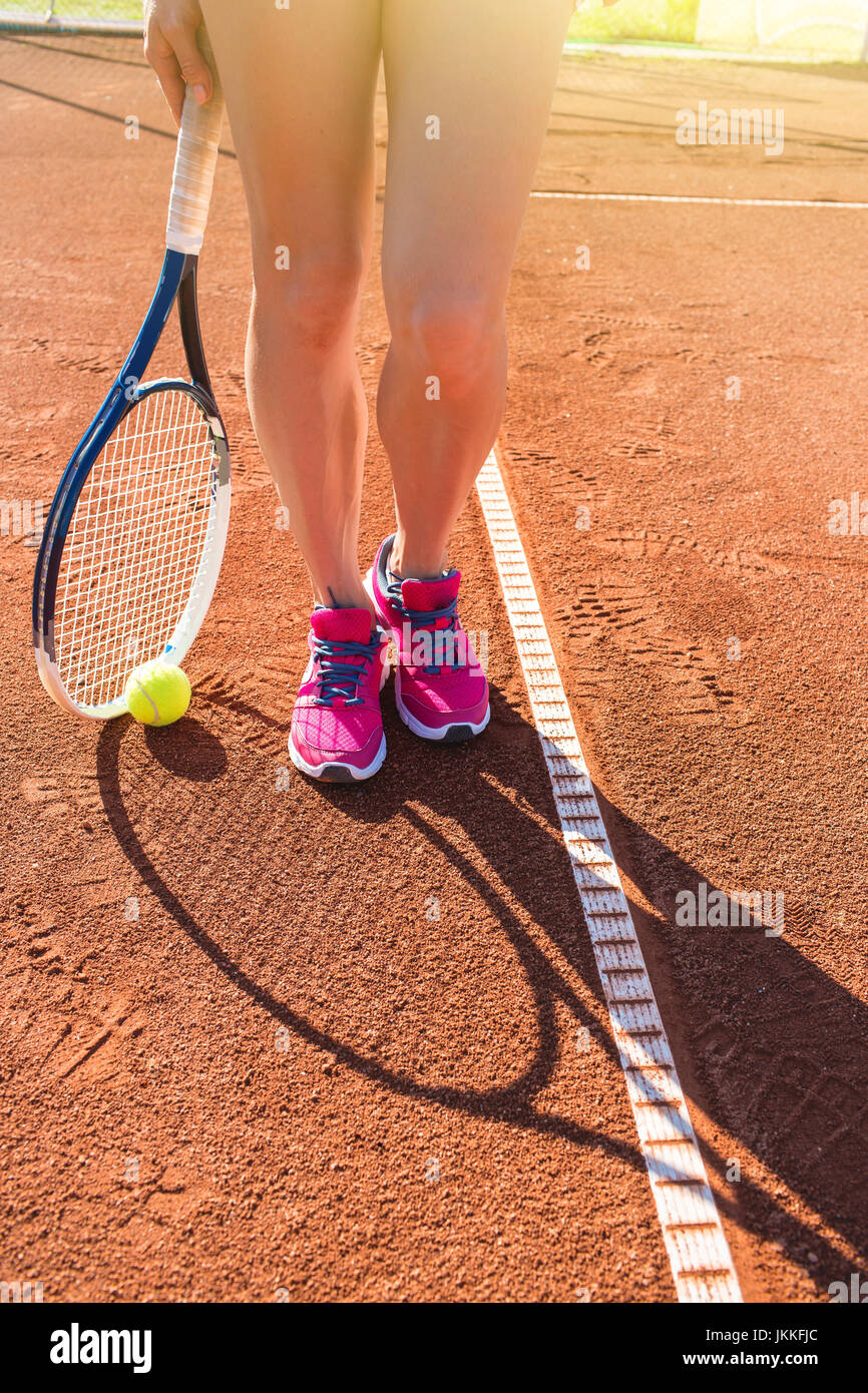 Female legs with tennis racket Stock Photo
