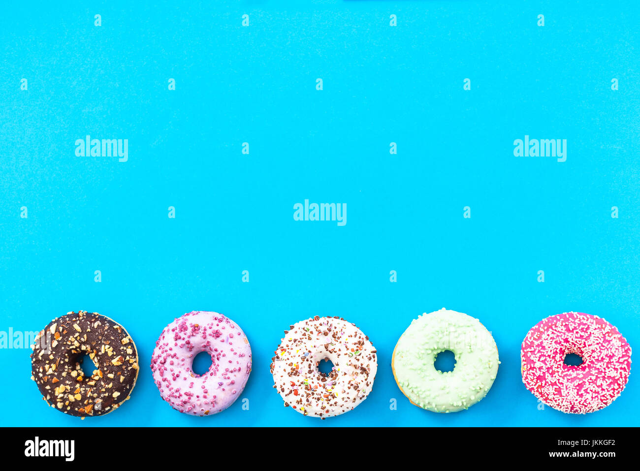 Colorful donuts border background, flat lay top view Stock Photo - Alamy