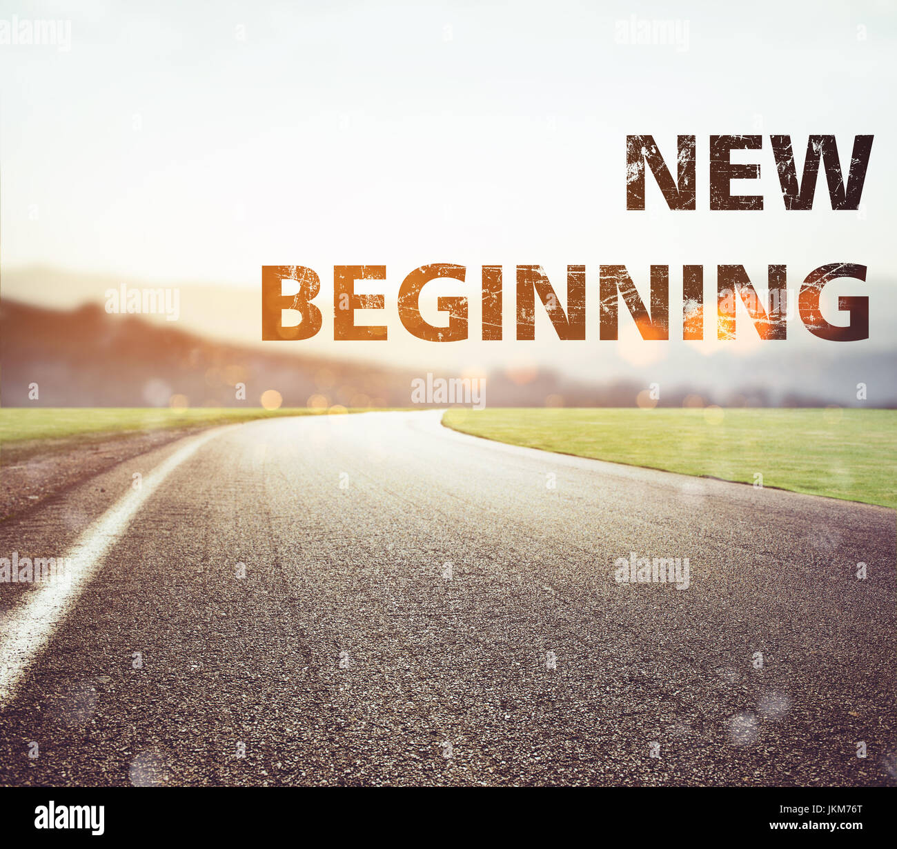 Road disappears from the view at sunset. Text new beginning Stock Photo
