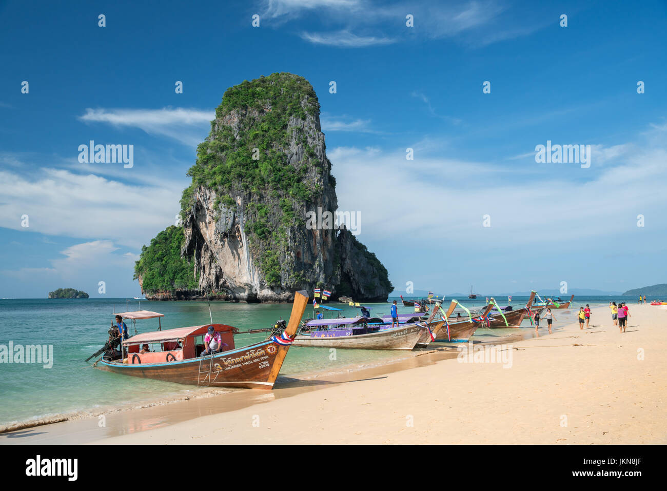 KRABI, THAILAND - DECEMBER 5 : Colorful long tail boats at beautiful Ao Nang beach on a background of blue sky and azure sea and limestone rocks, Phi  Stock Photo