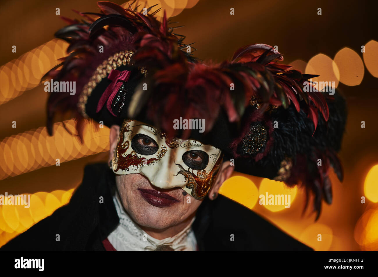 Celebrating Carnival in Venice 2017 in a Bauta mask with a hat garnished with red feathers. Stock Photo