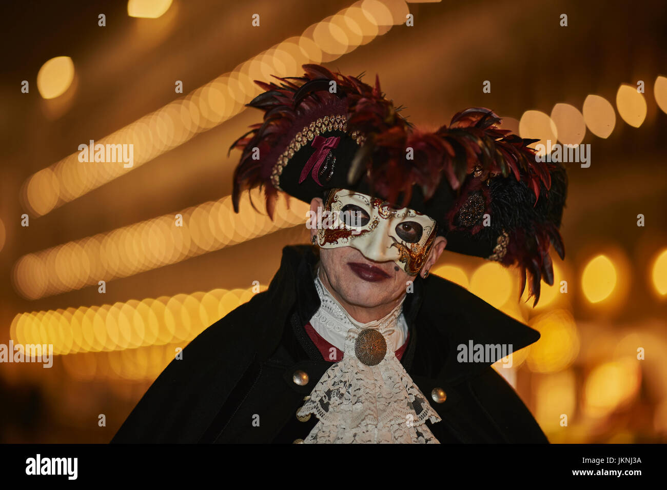 Celebrating Carnival in Venice 2017 in a Bauta mask with a hat garnished with red feathers. Stock Photo