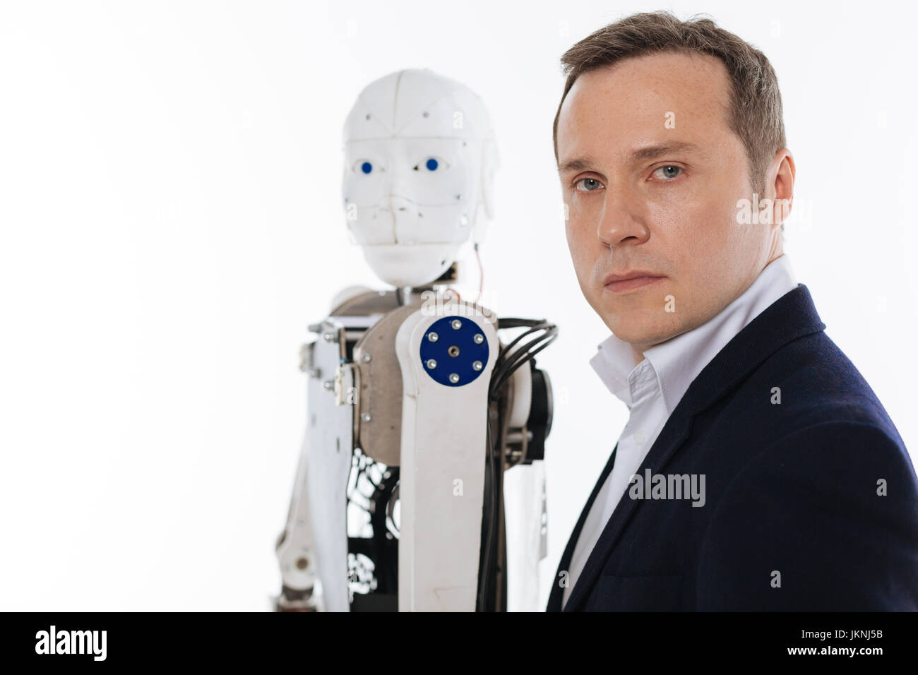 Progressive inventor and his robot standing in the same poses Stock Photo