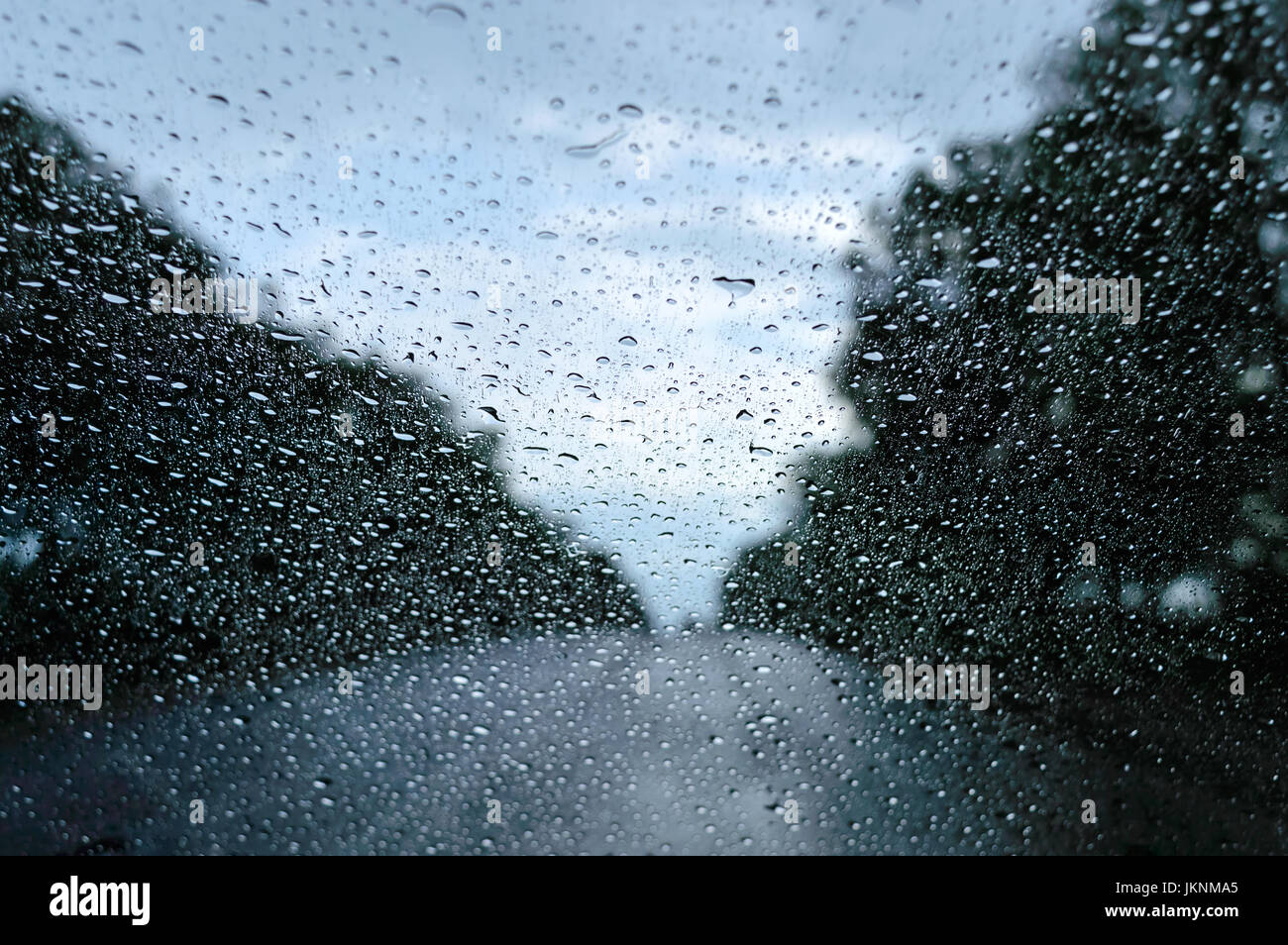 A view of the rainy weather through the windshield of a car that rides ...
