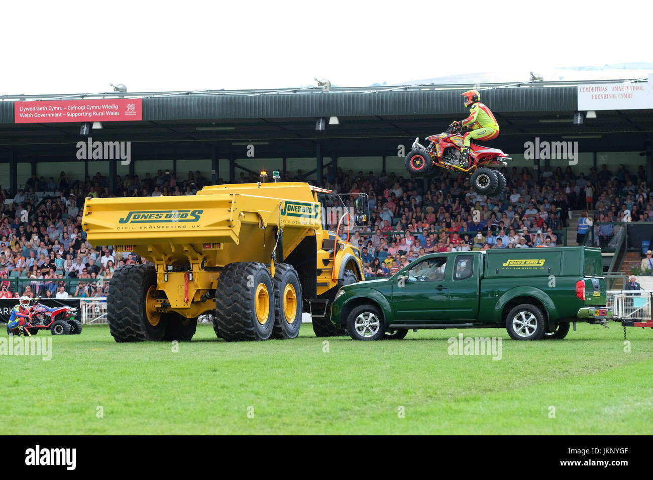 Royal Welsh Show - Monday 24th July 2017 - The Kangaroo Kid motorcycle stuntman is too low as he tries to jump a green pickup truck and a large yellow dumper truck in front of the spectators at the Royal Welsh Show. His quad bike hits the far side of the yellow dumper truck throwing him to the ground. The stuntman was taken away by ambulance condition unknown. Today is the Opening Day of the largest four day agricultural show in the UK. Photo Steven May / Alamy Live News Stock Photo
