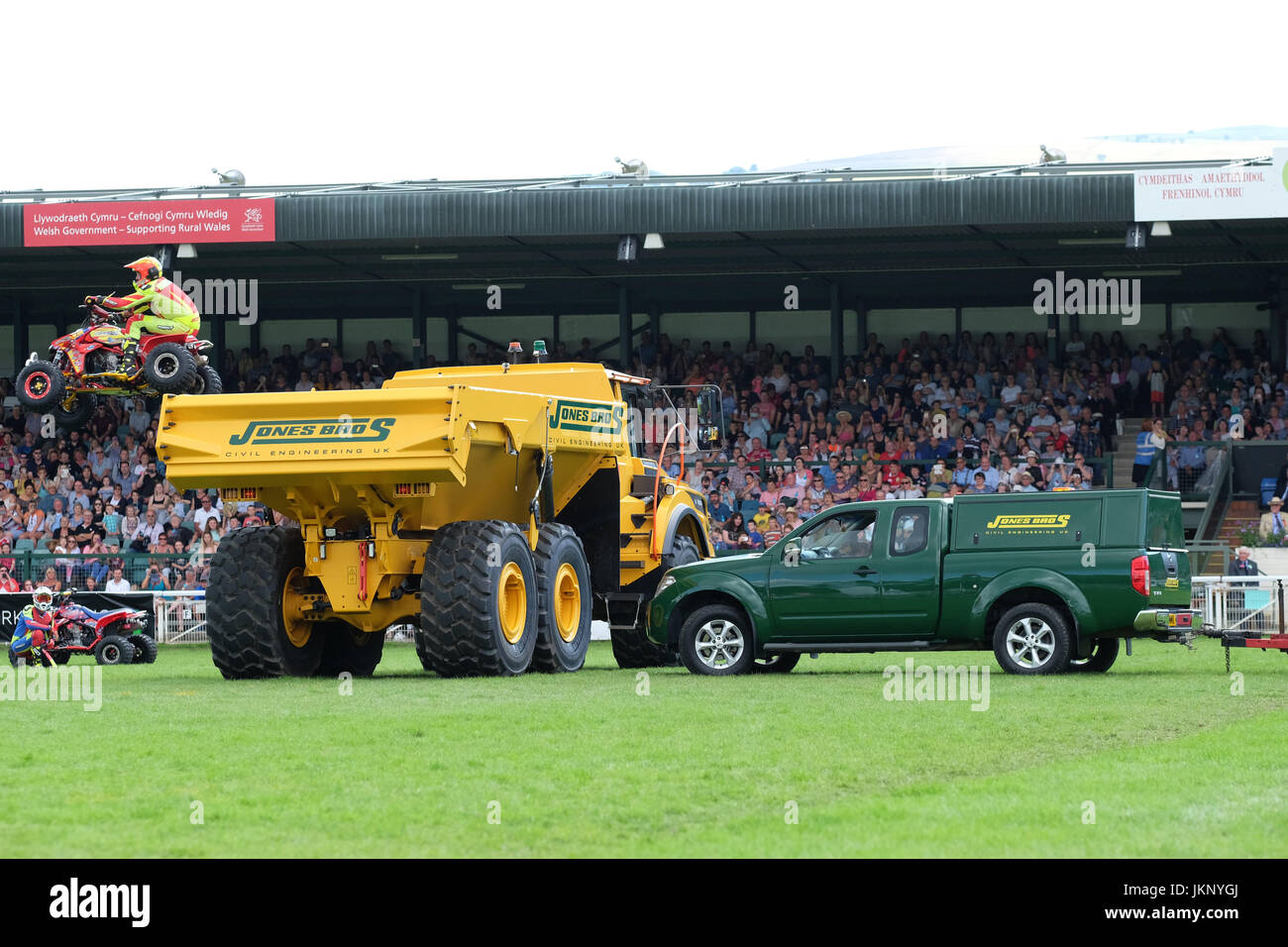 Royal Welsh Show - Monday 24th July 2017 - The Kangaroo Kid motorcycle stuntman is too low as he tries to jump a green pickup truck and a large yellow dumper truck in front of the spectators at the Royal Welsh Show. His quad bike hits the far side of the yellow dumper truck throwing him to the ground. The stuntman was taken away by ambulance condition unknown. Today is the Opening Day of the largest four day agricultural show in the UK. Photo Steven May / Alamy Live News Stock Photo