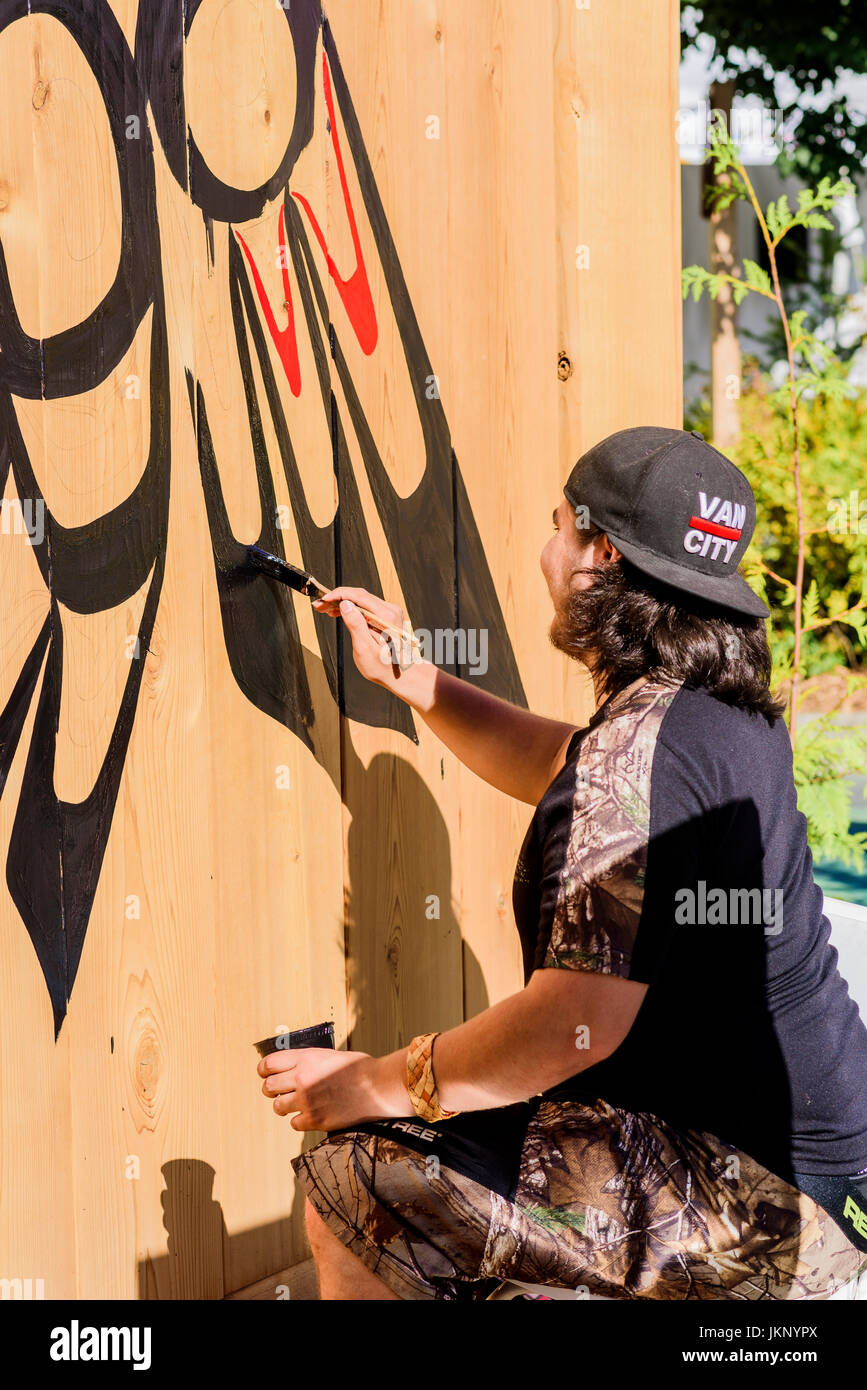 Vancouver, Canada. 23rd July, 2017. Man painting emblem on shed, The