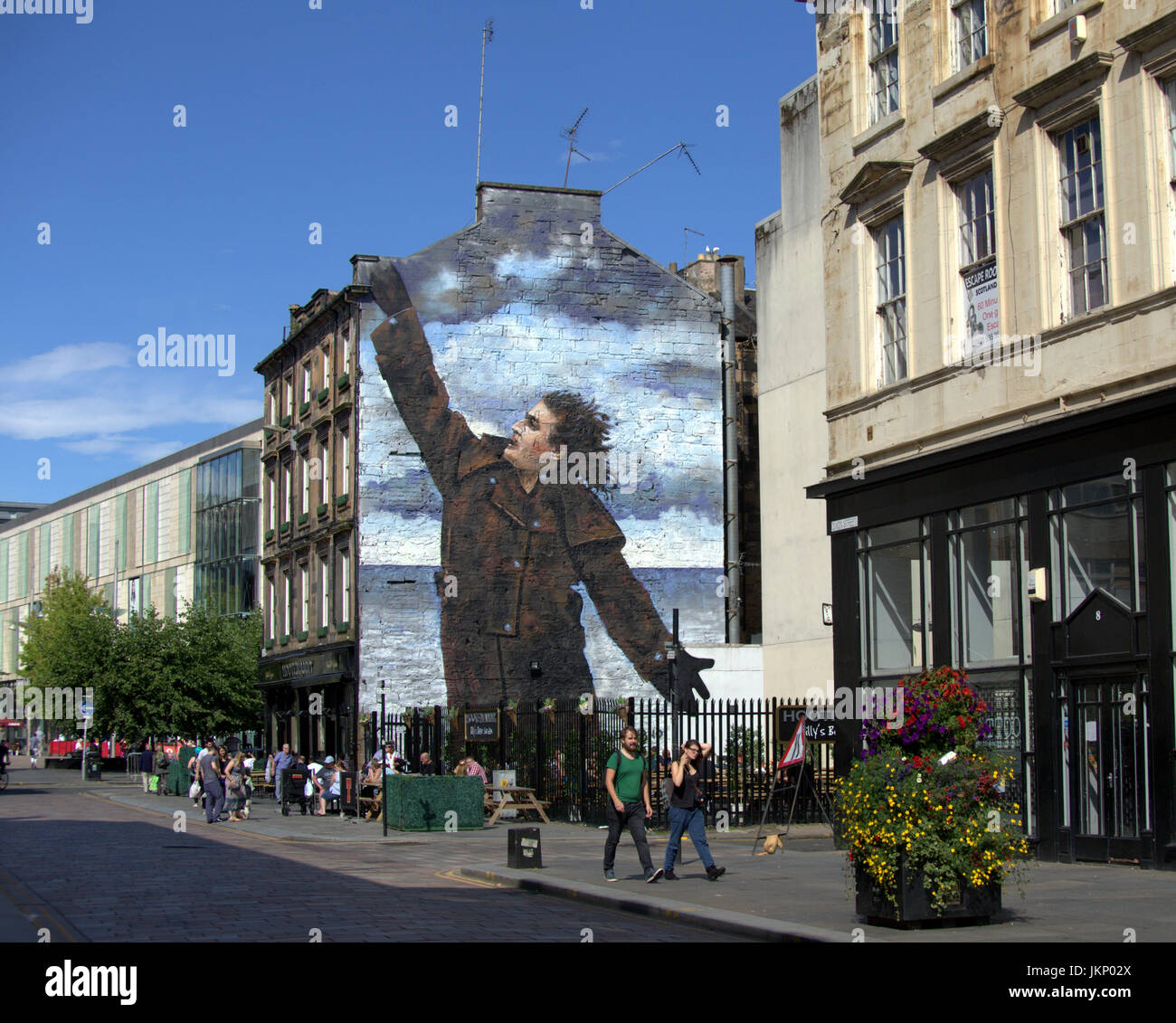 Glasgow, Scotland, UK. 24th July. Summer weather returns and locals enjoy the summer  in the city at the Billy Connolly mural by Jack Vettriano as locals and tourists enjoy some of the scorching UK weather Credit Gerard Ferry/Alamy news Stock Photo