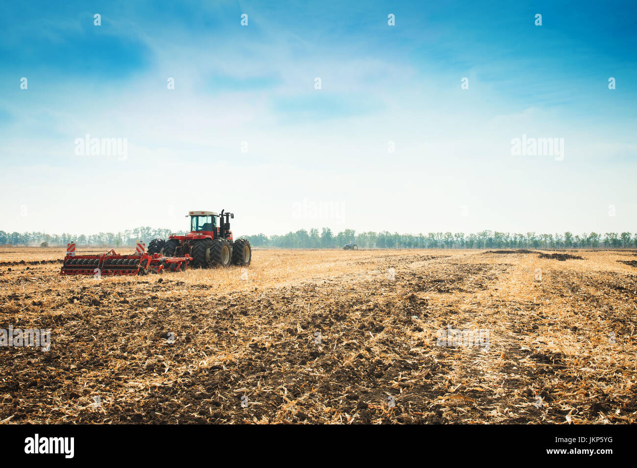 Modern tractor in the field with complex for the plowing. The concept ...