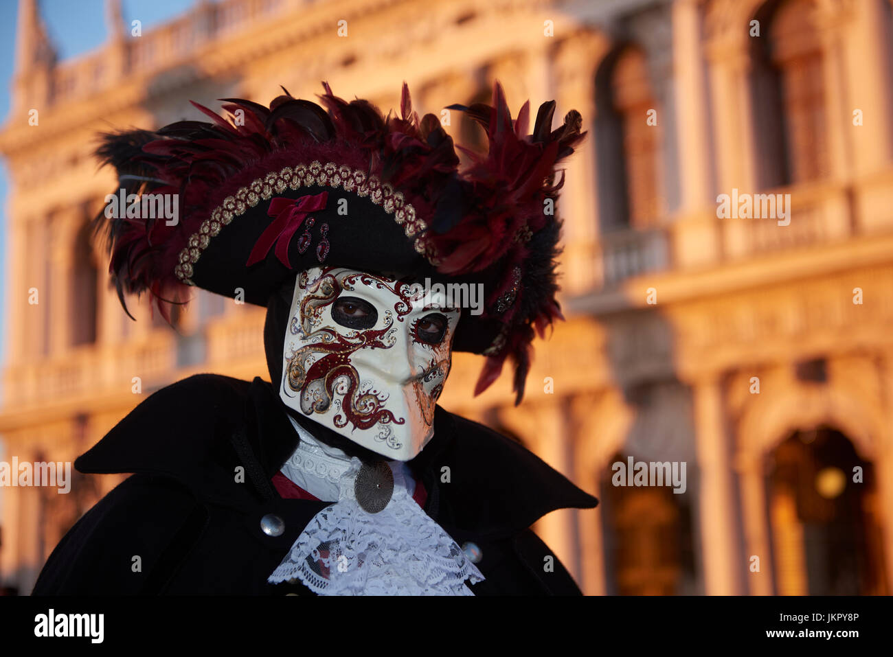 Celebrating Carnival in Venice 2017 in a Bauta mask with a hat garnished with red feathers. Stock Photo