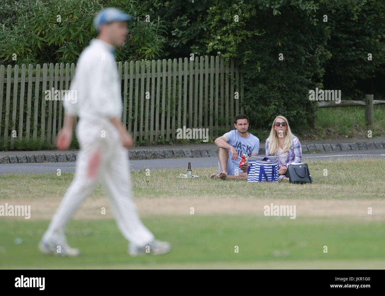 Spectators enjoying a village cricket match between Tilford and Grayswood being played at Tilford Green in Waverley, Surrey. Stock Photo