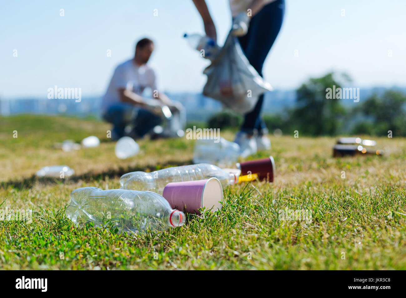 Devoted energetic people collecting litter on a grass Stock Photo Alamy