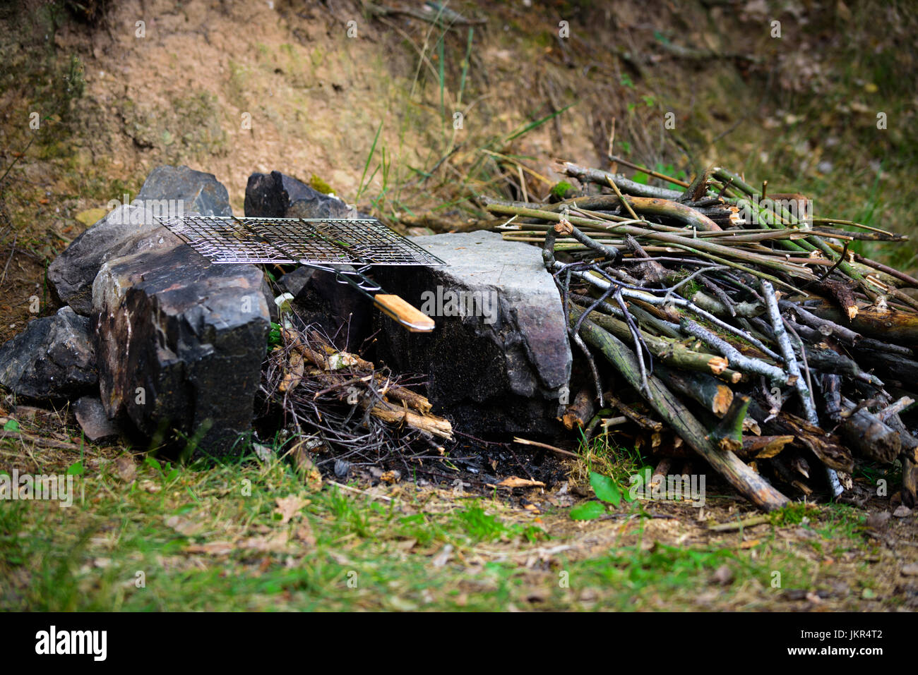 Campfire with empty grilling basket, adventure lifestyle camping vacation food concept Stock Photo