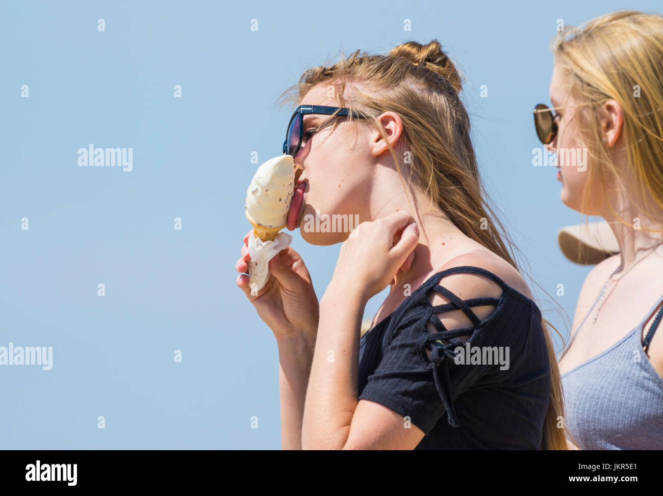 girl eating an ice cream cone on a hot day in Summer. Stock Photo