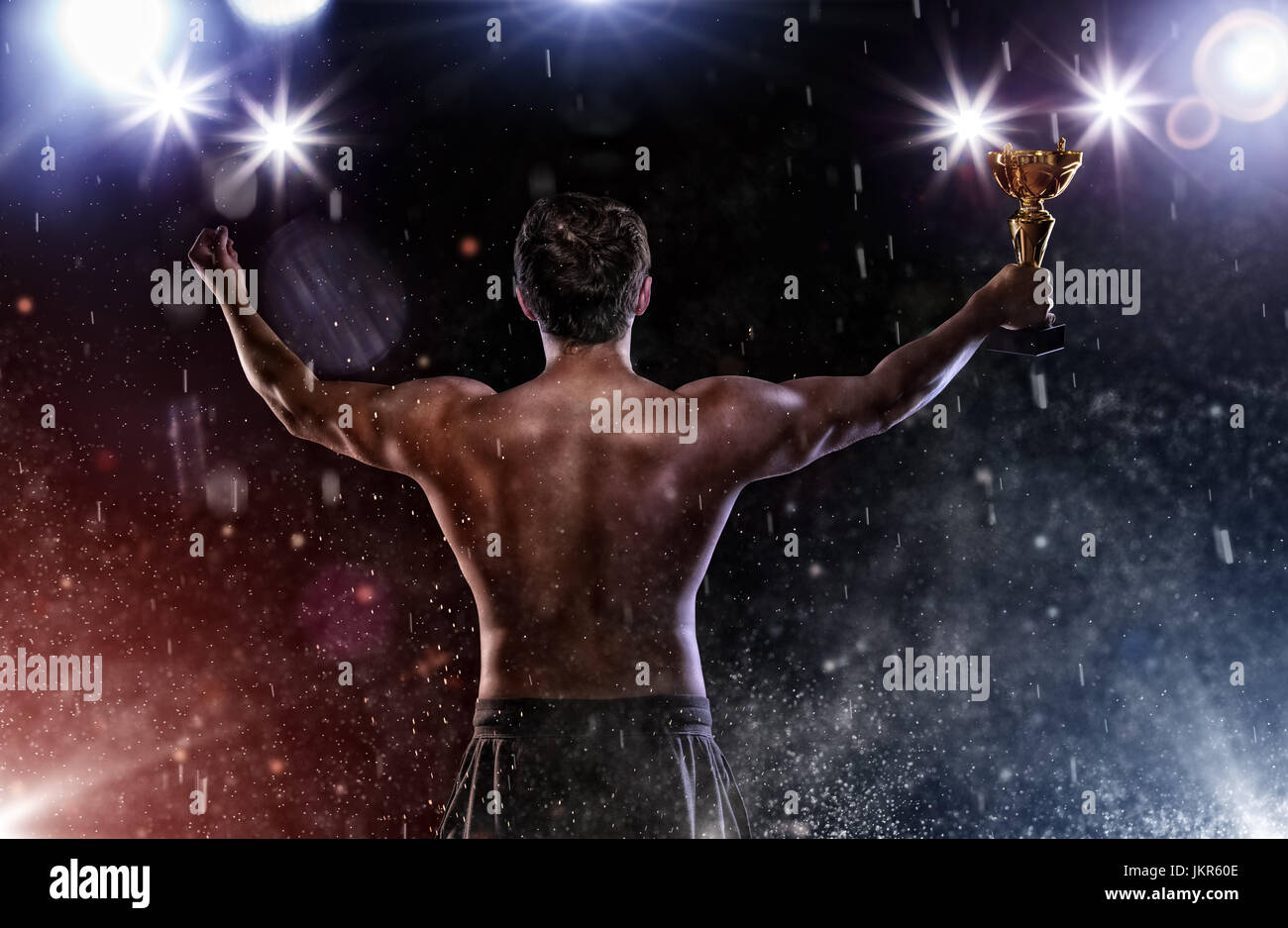 Back view of man fighter holding trophy cup in hands, victory gesture. Concept of hard sport, glory and success. Very high resolution image Stock Photo