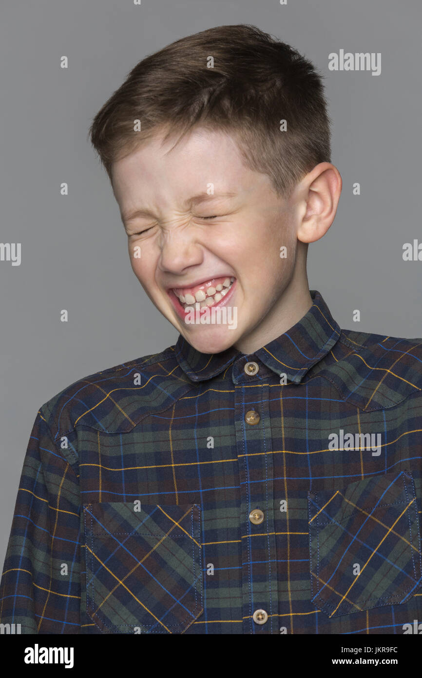 Cheerful boy with eyes closed against gray background Stock Photo