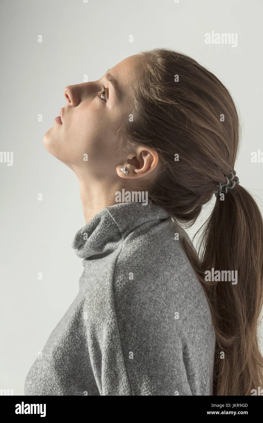 Profile view of teenage girl looking up against white background Stock Photo