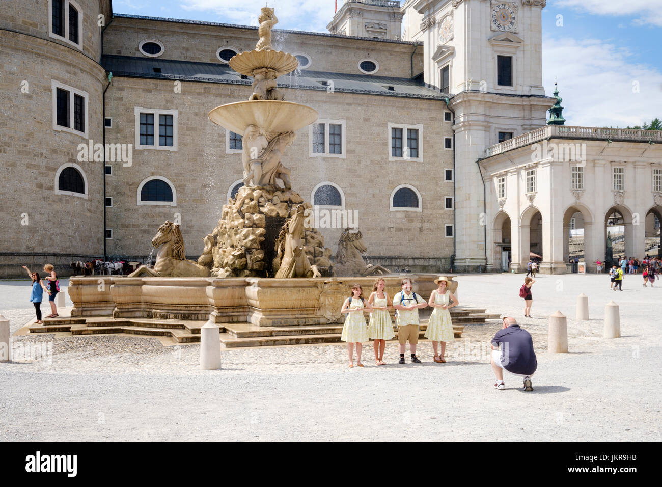 Residenzbrunnen on Residenzplatz with tourists posing in Sound of Music costumes, Salzburg, Austria Stock Photo