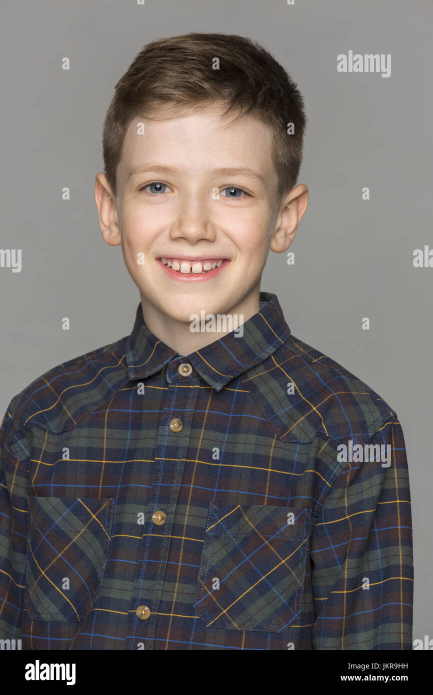 Portrait of smiling boy against gray background Stock Photo
