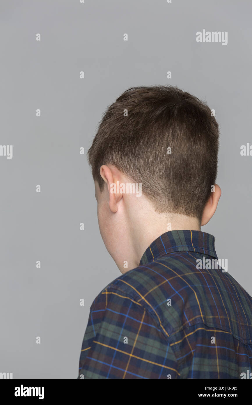 Rear view of boy against gray background Stock Photo