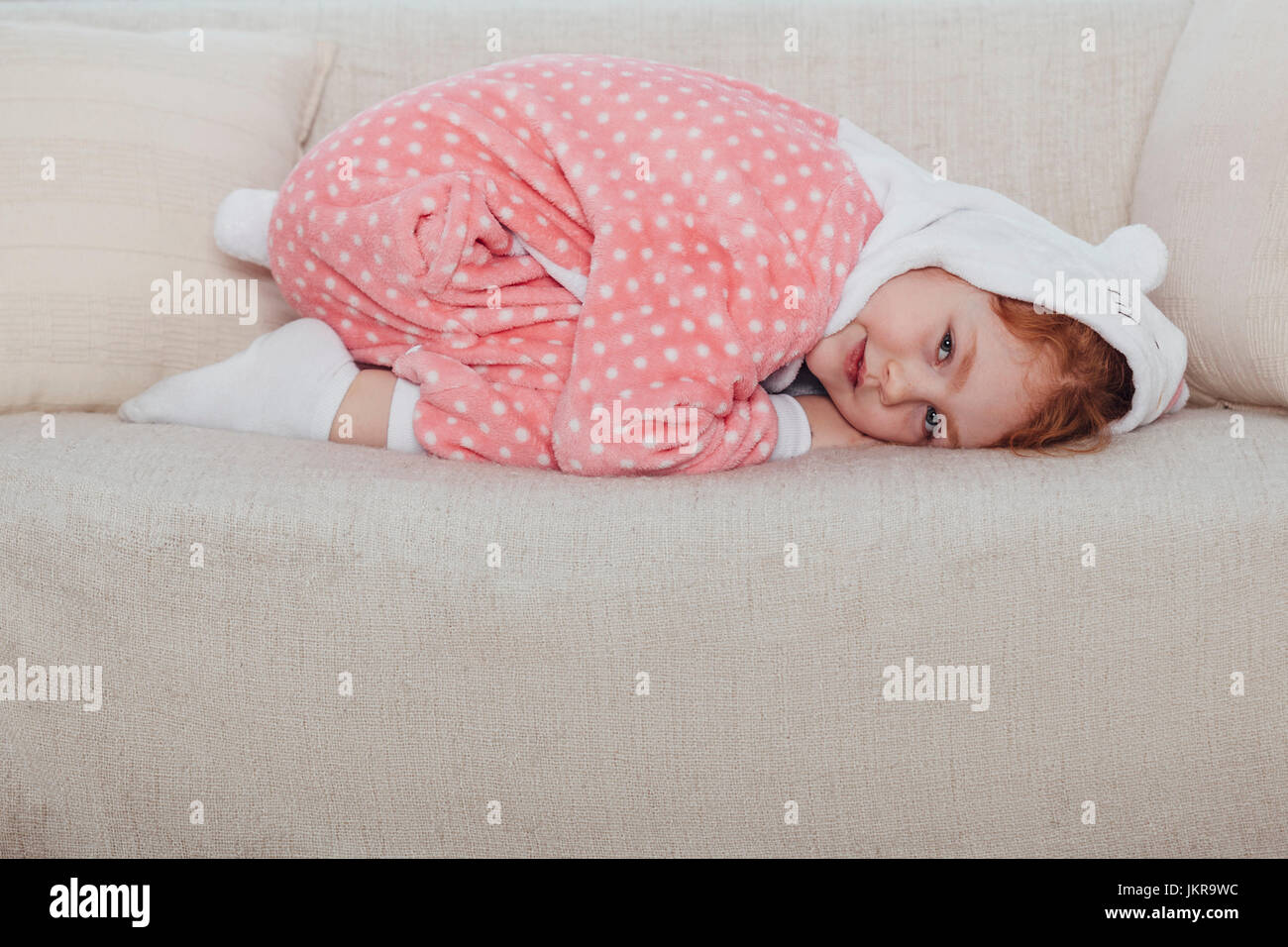 Portrait of smiling girl kneeling on sofa at home Stock Photo