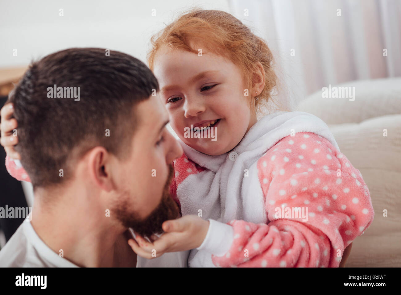 Smiling daughter playing with father in living room at home Stock Photo