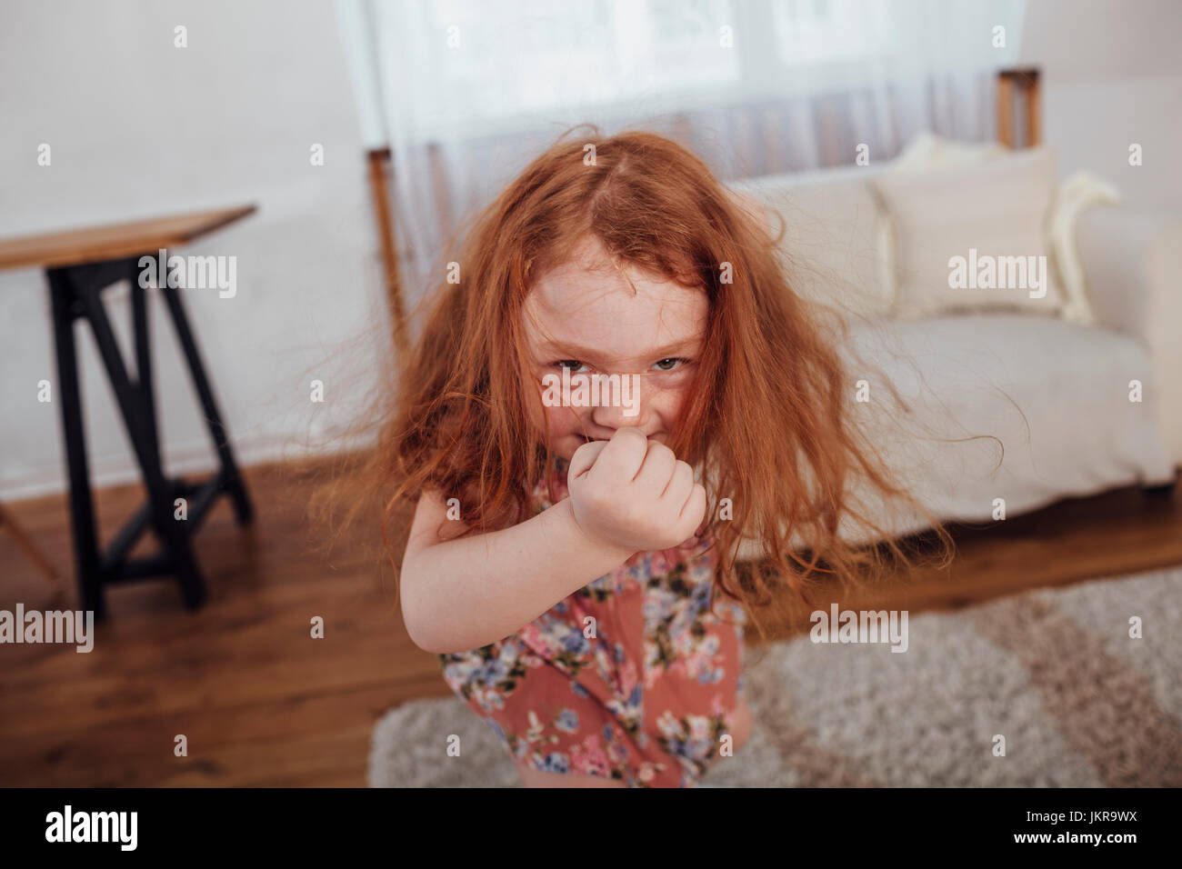 Portrait of happy girl dancing in living room at home Stock Photo