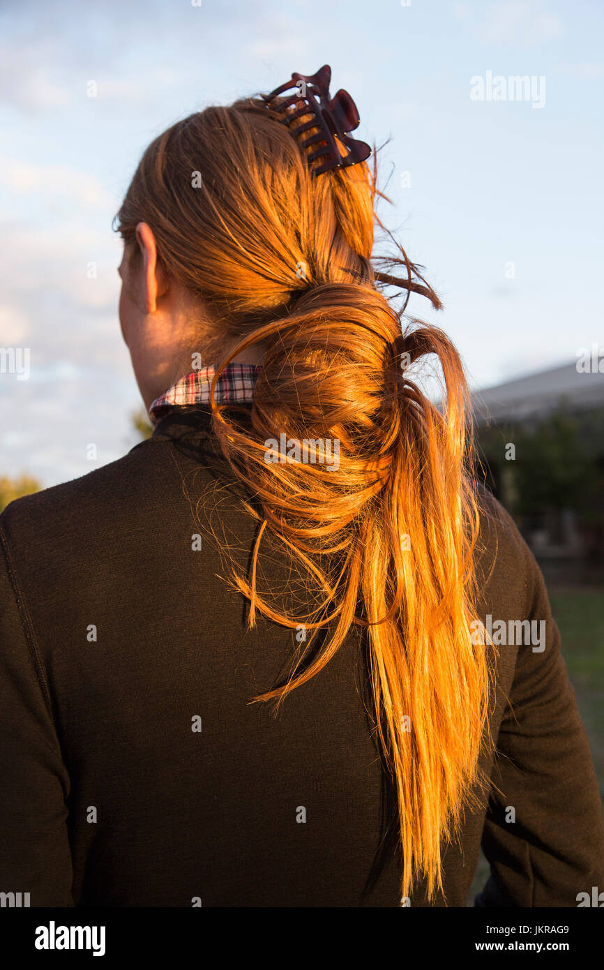 Rear view of woman with long red hair at dusk Stock Photo