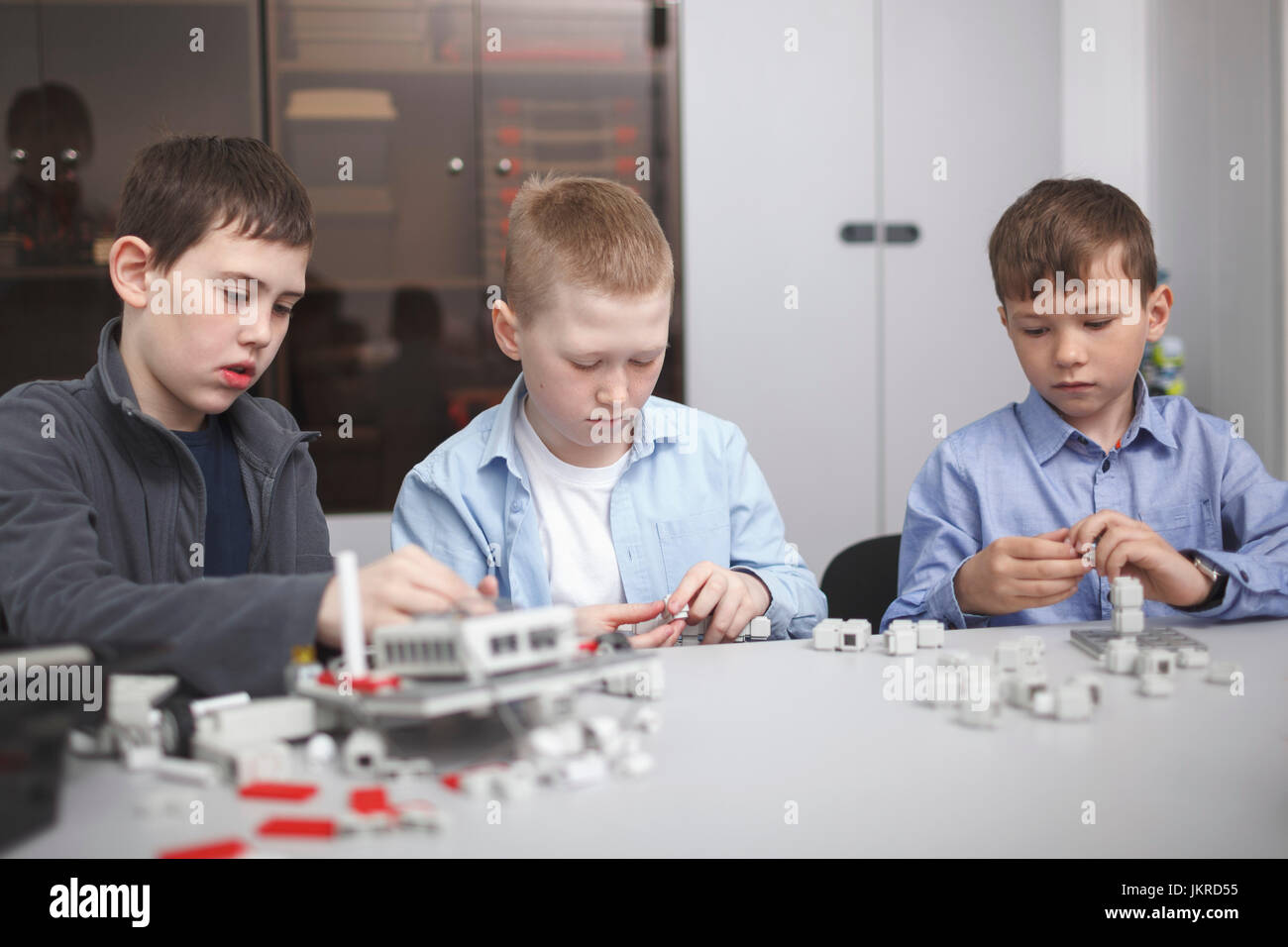 Students working on machinery at table in classroom Stock Photo